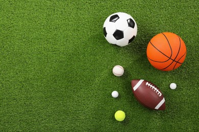 Photo of Many different sports balls on green grass, flat lay. Space for text
