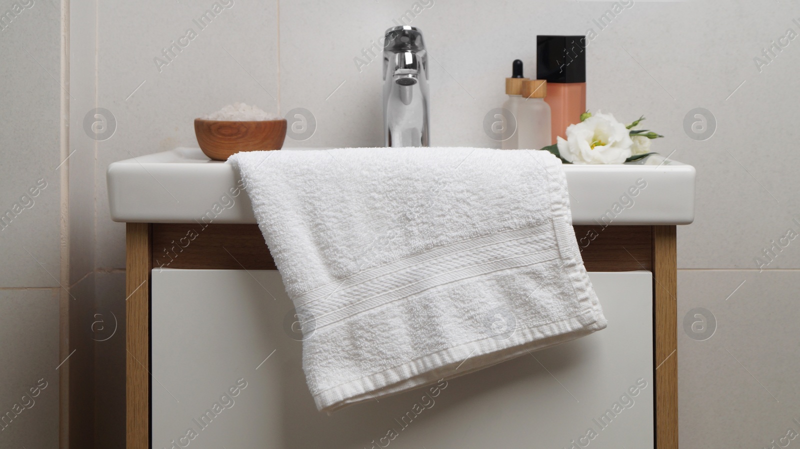 Photo of White soft towel on sink in bathroom