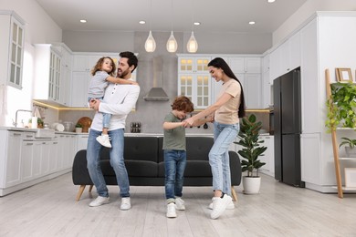 Photo of Happy family dancing and having fun at home, low angle view
