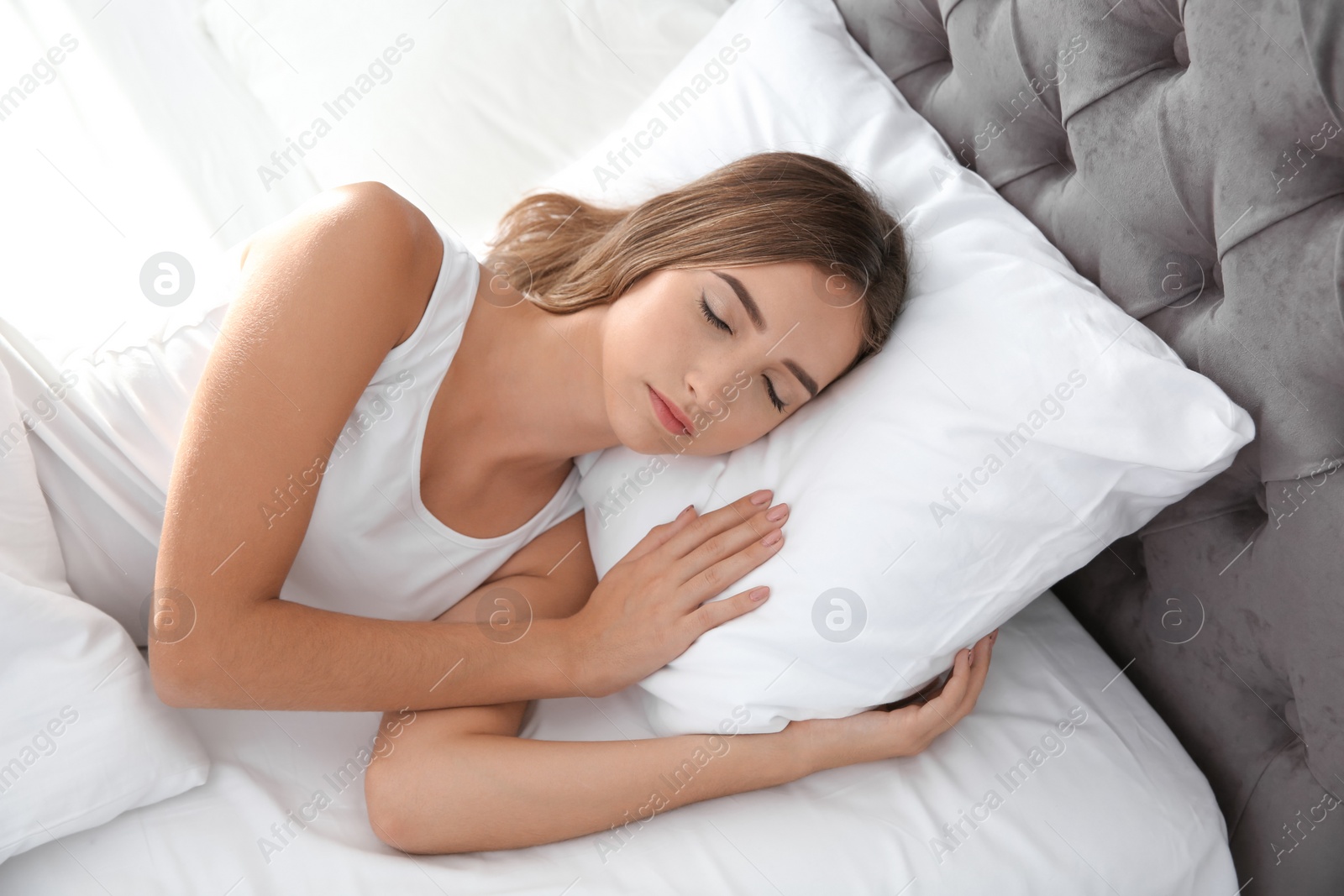 Photo of Beautiful teen girl sleeping with comfortable pillow in bed at home