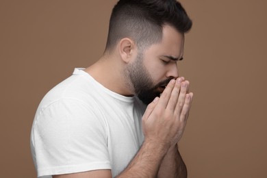 Photo of Sick man coughing on brown background. Cold symptoms