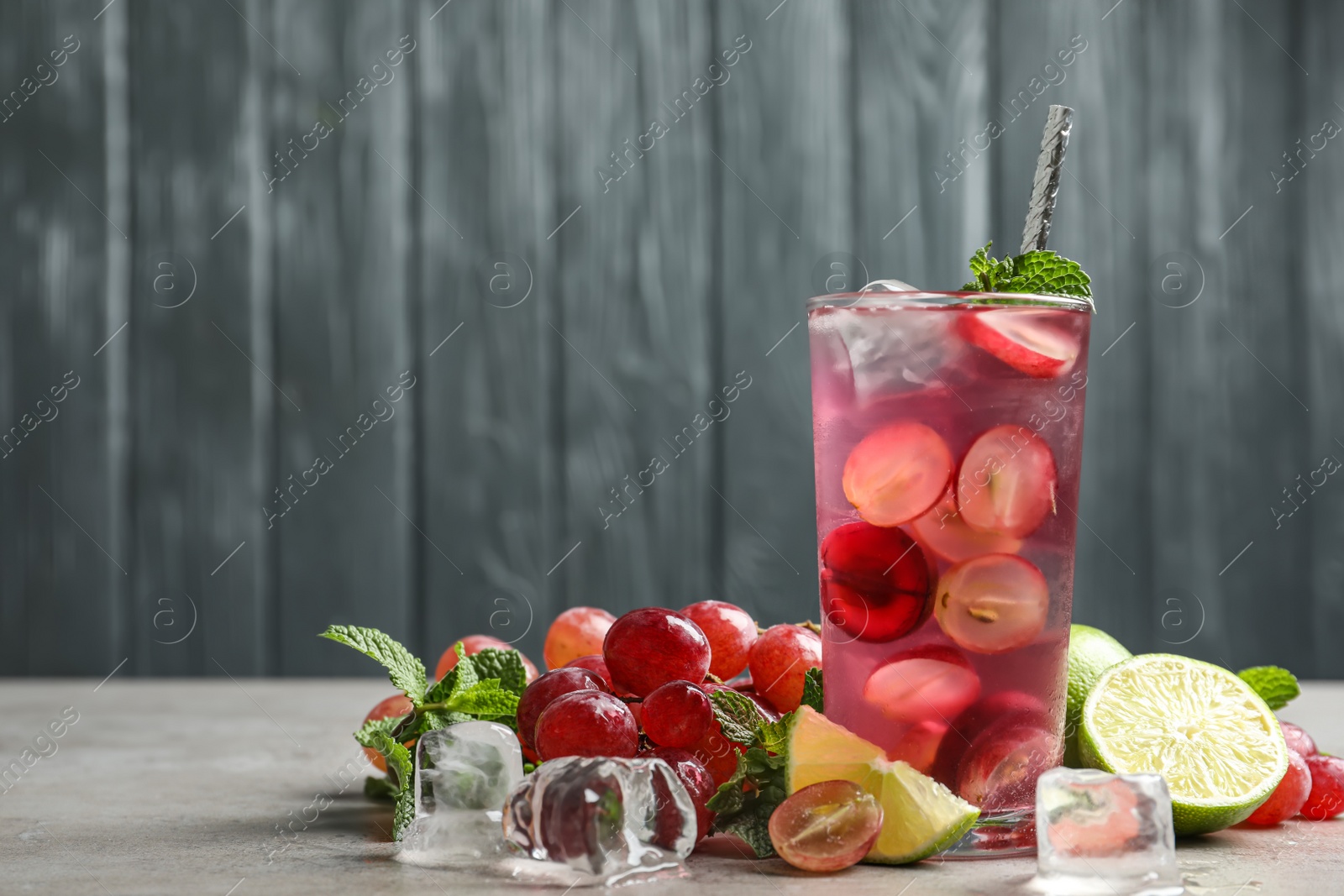 Photo of Soda water with grapes, ice and mint on table, space for text. Refreshing drink