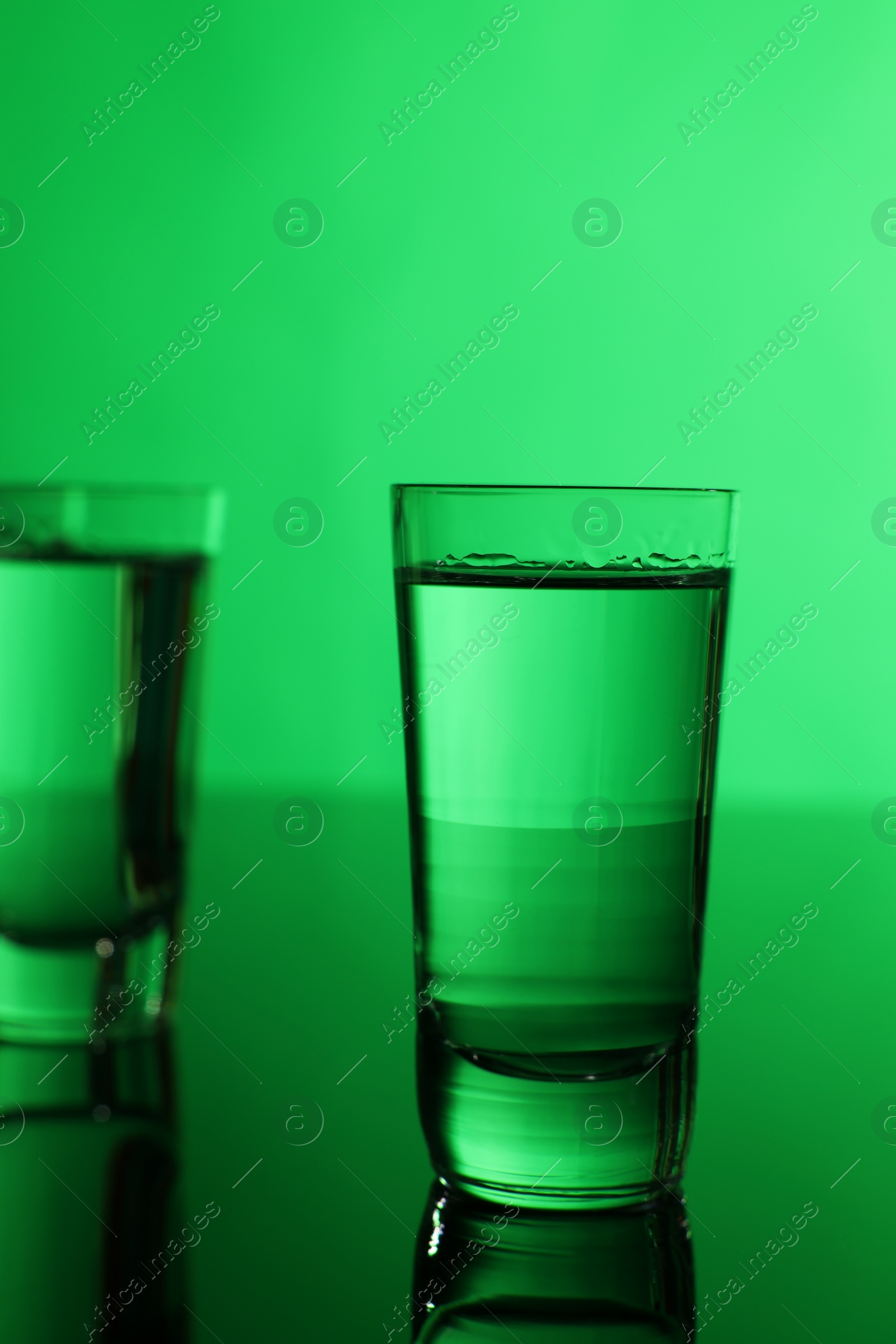 Photo of Vodka on table against green background, space for text