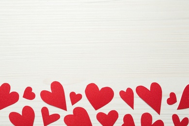 Decorative hearts on white wooden table, flat lay with space for text. Valentine's day