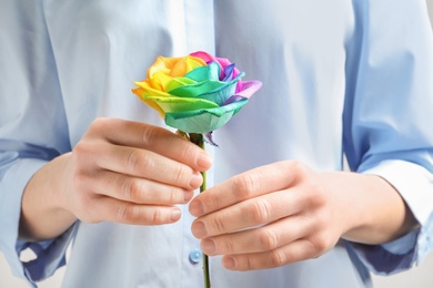 Photo of Woman holding rainbow rose flower, closeup