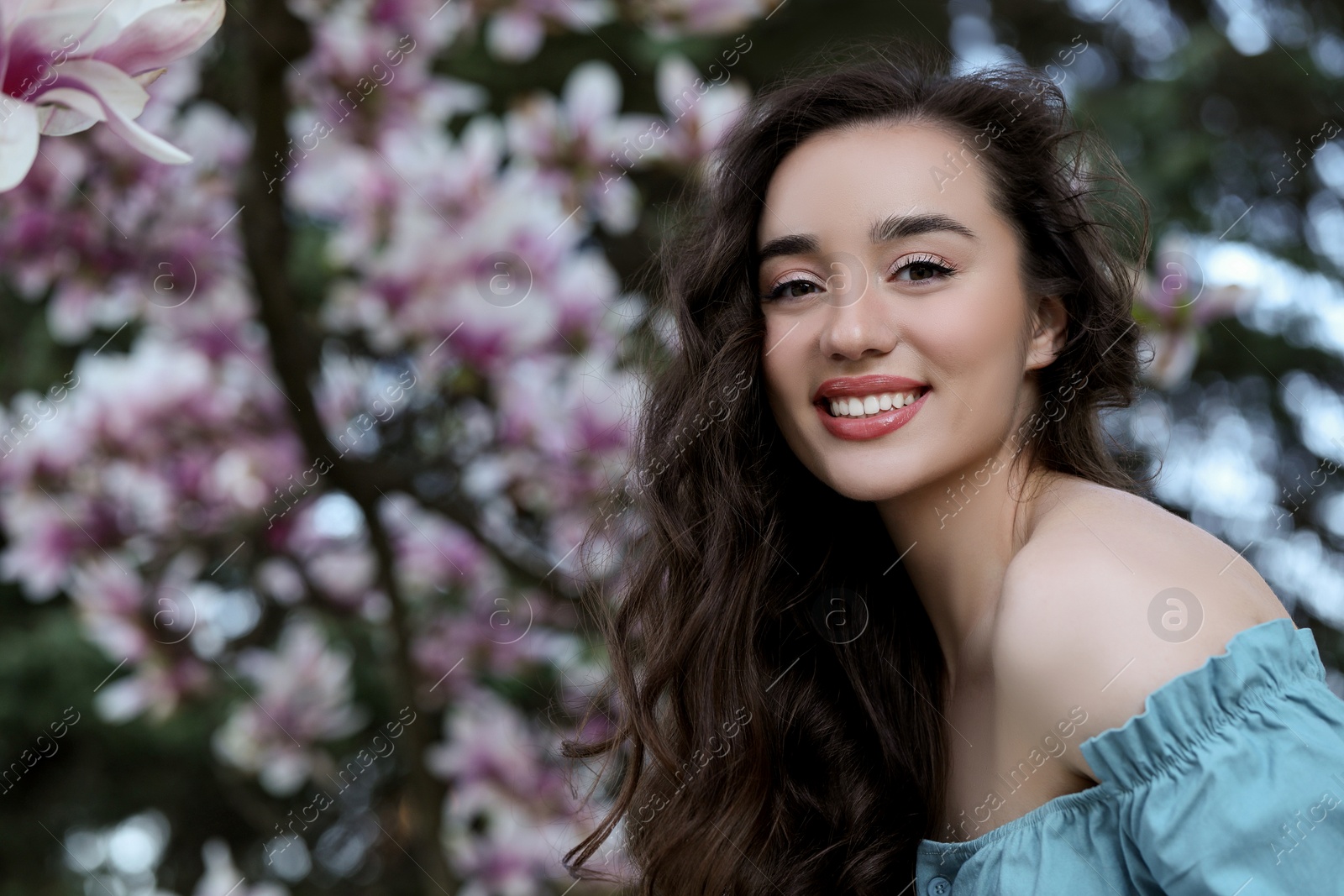 Photo of Beautiful woman near blossoming magnolia tree on spring day