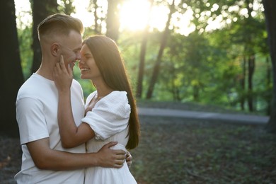 Photo of Happy young couple having good time together in park, space for text