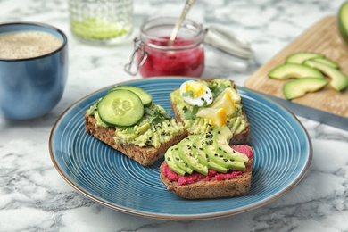 Photo of Crisp rye toasts with avocado on plate