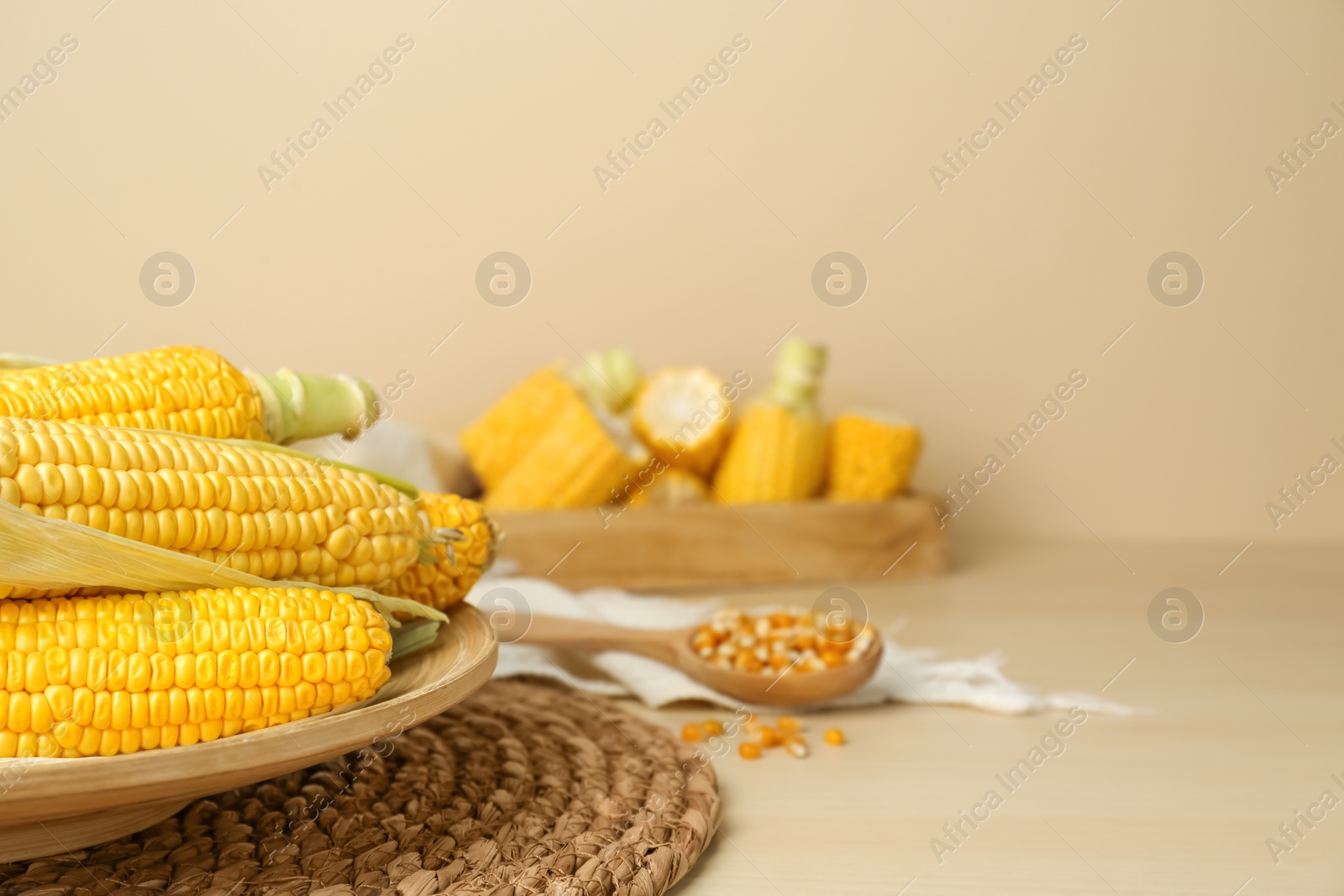 Photo of Tasty fresh corn cobs on wooden table, space for text