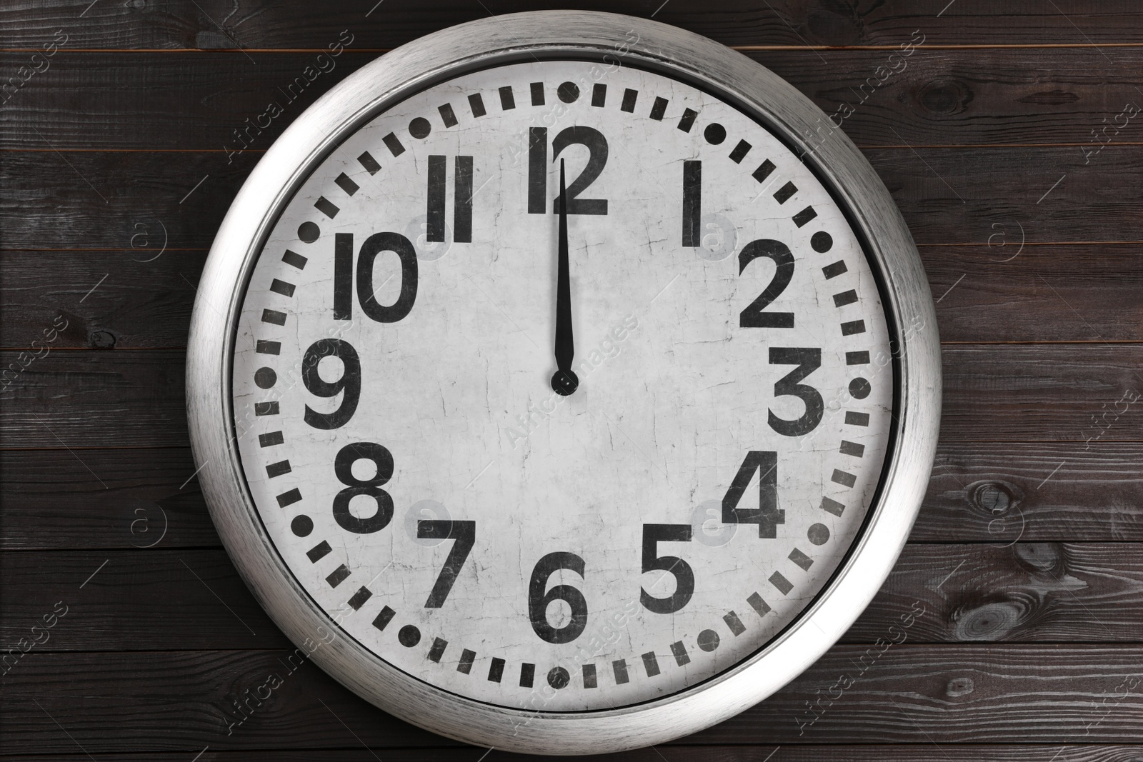 Photo of Stylish analog clock hanging on wooden wall