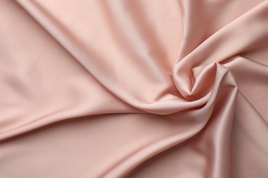 Crumpled pink silk fabric as background, top view