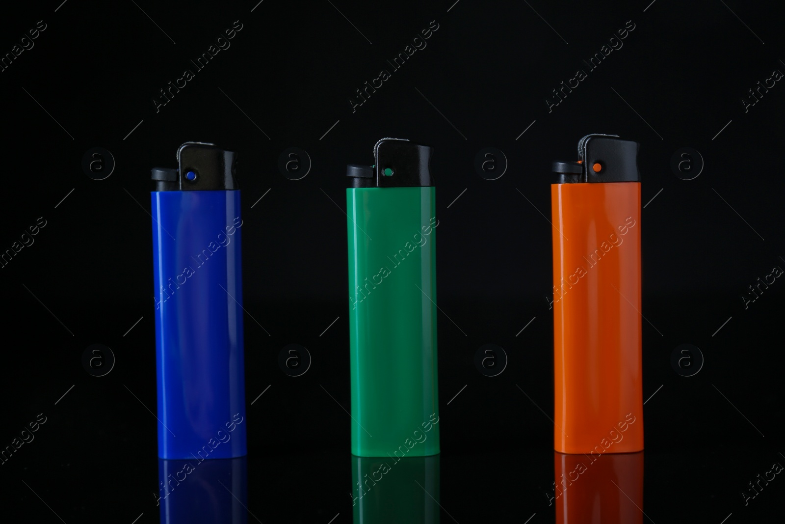 Photo of Colorful plastic cigarette lighters on black background