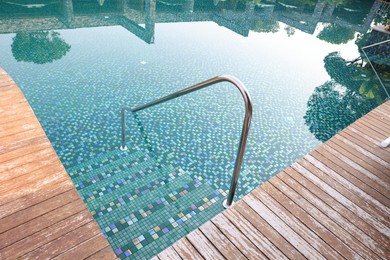 Outdoor swimming pool with steps and rail at resort