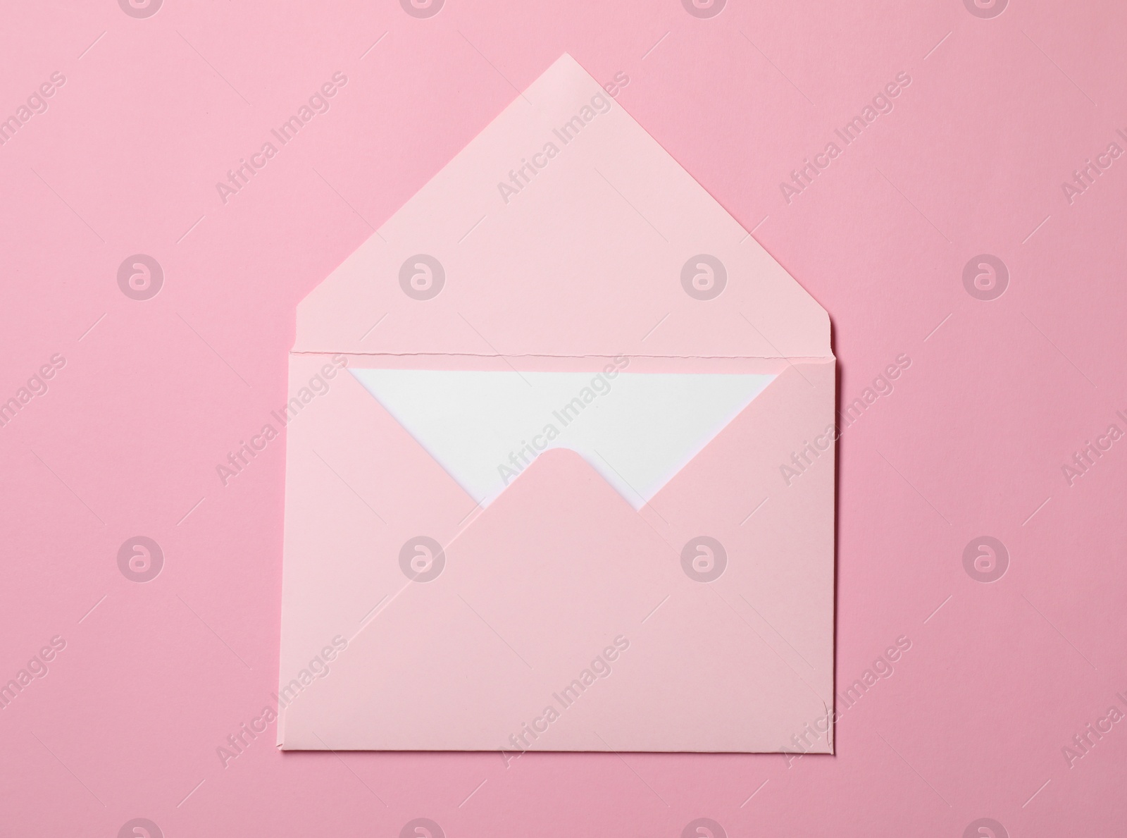 Photo of Letter envelope with card on pink background, top view