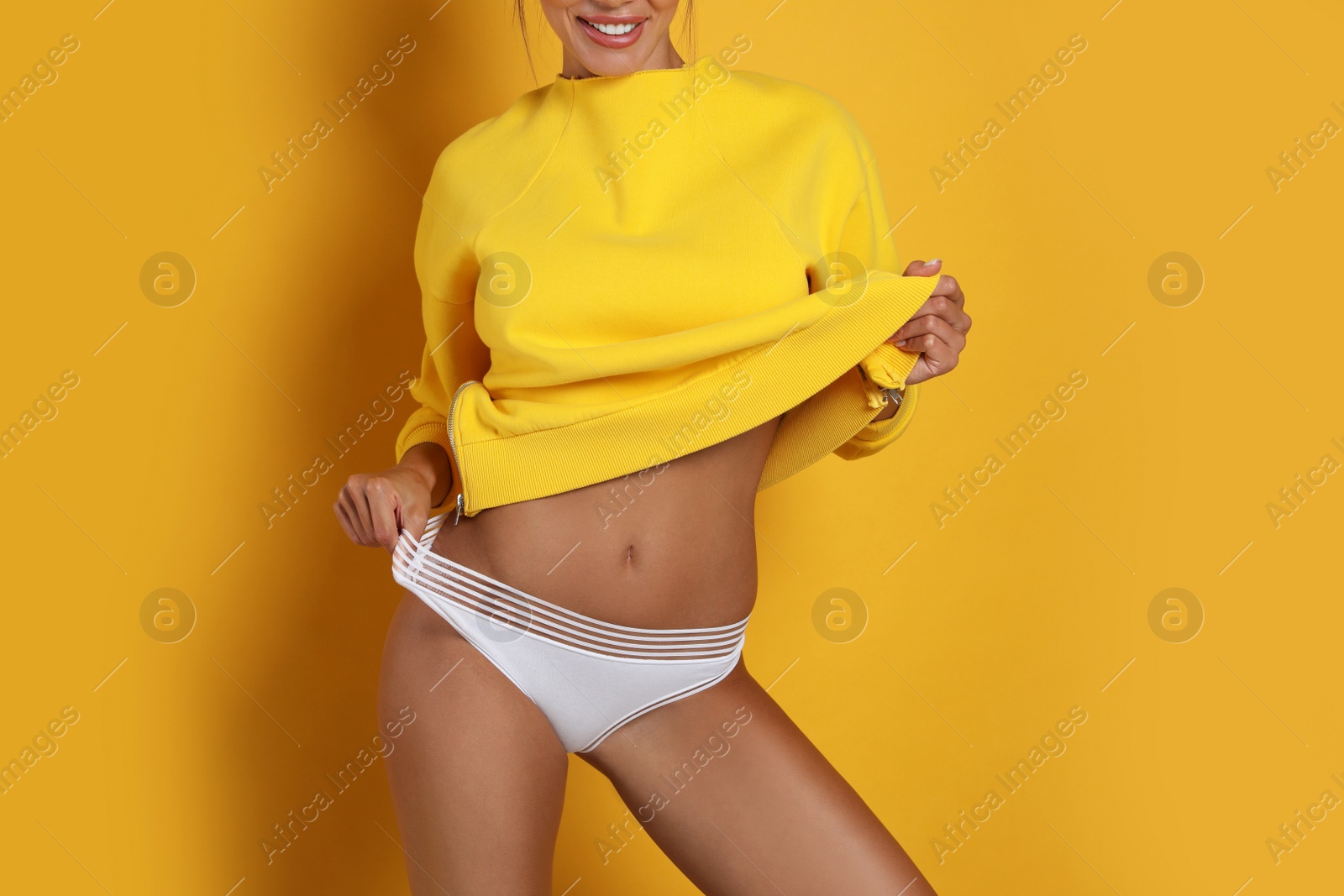 Photo of Woman in white panties on yellow background, closeup