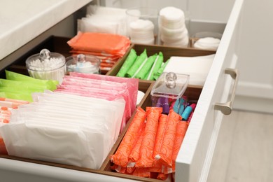 Photo of Storage of different feminine hygiene products in drawer indoors, closeup