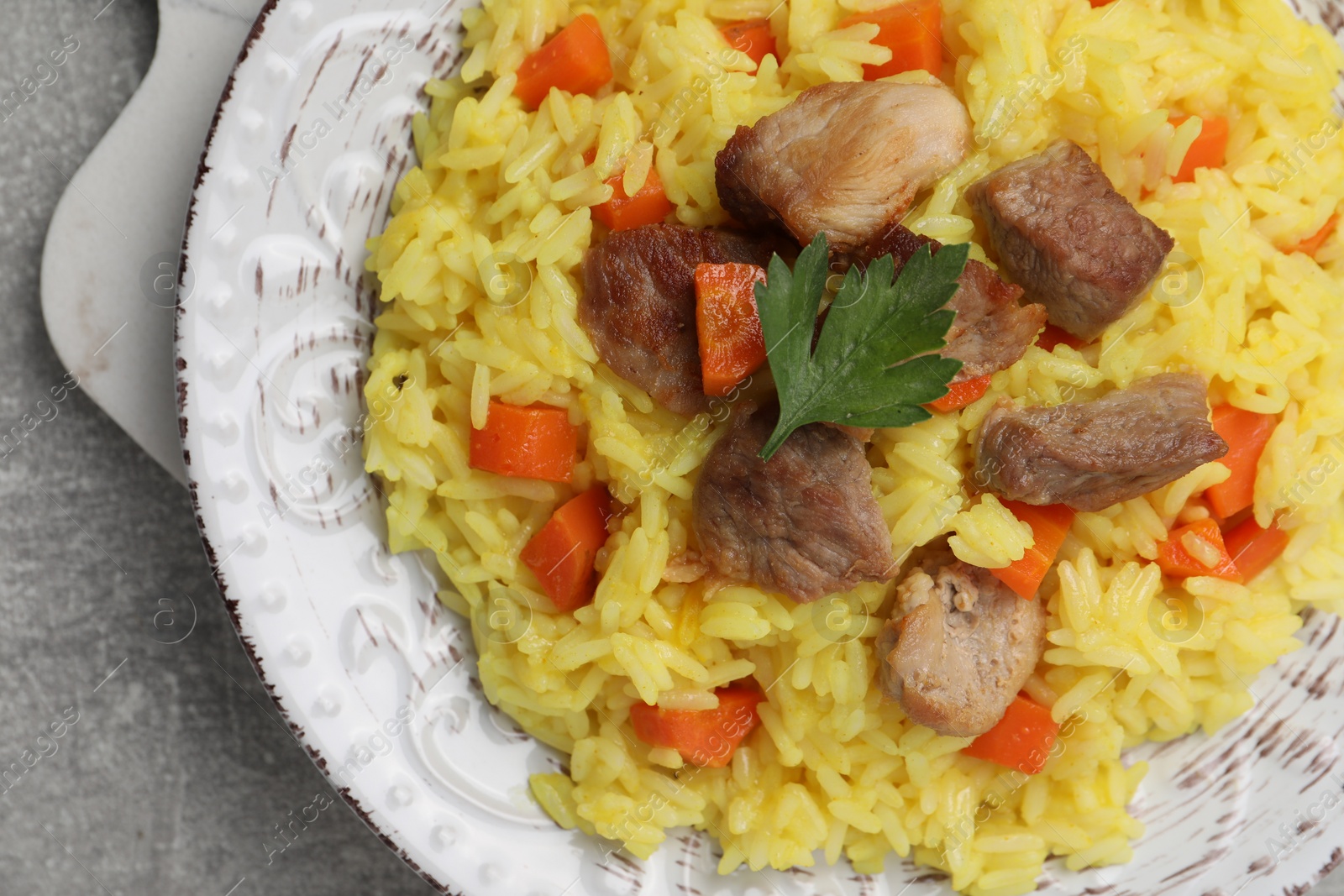Photo of Delicious pilaf with meat on light grey table, closeup