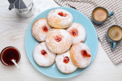 Delicious jam donuts served with coffee on white wooden table, flat lay