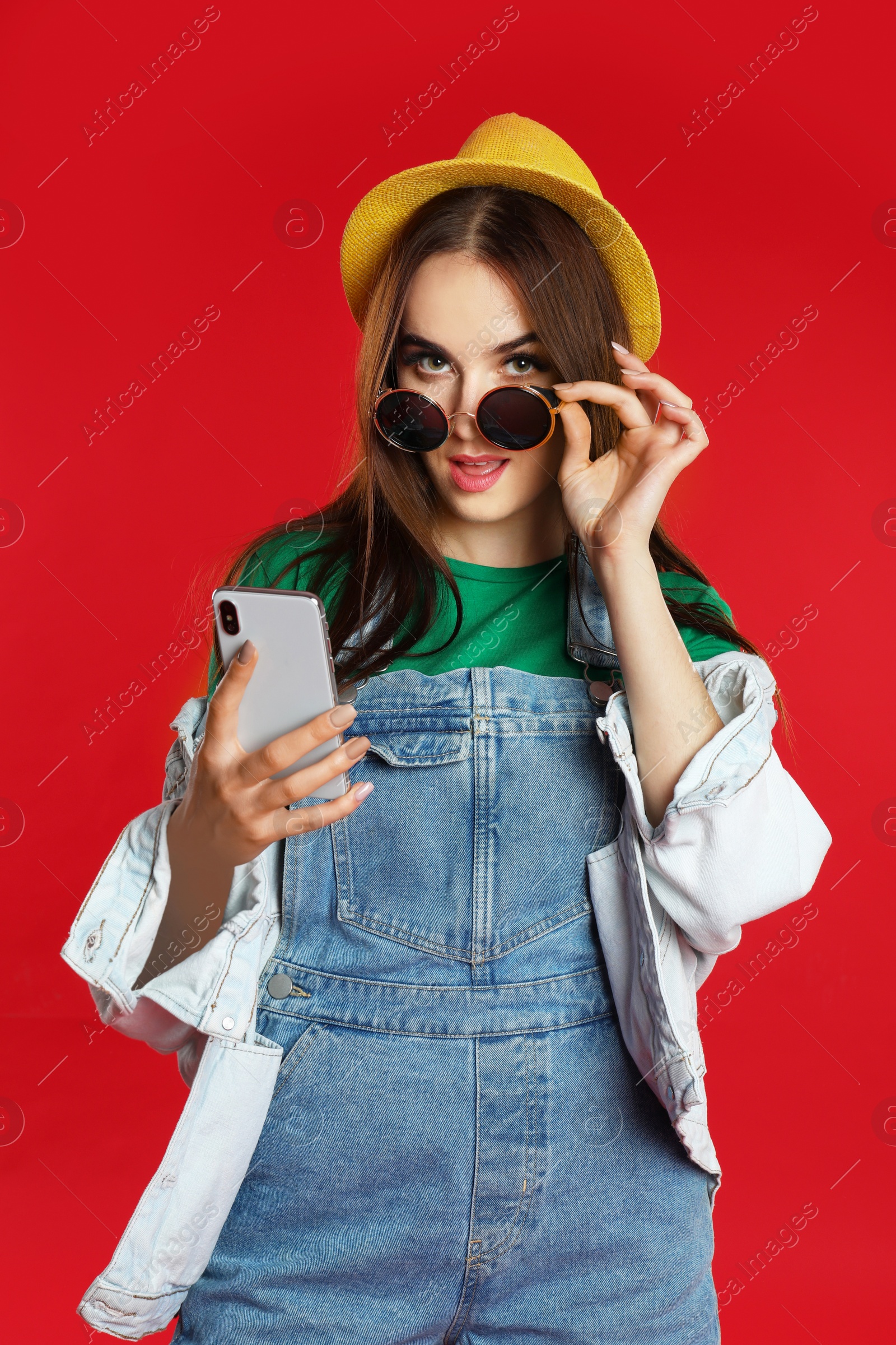 Photo of Beautiful woman with mobile phone on red background