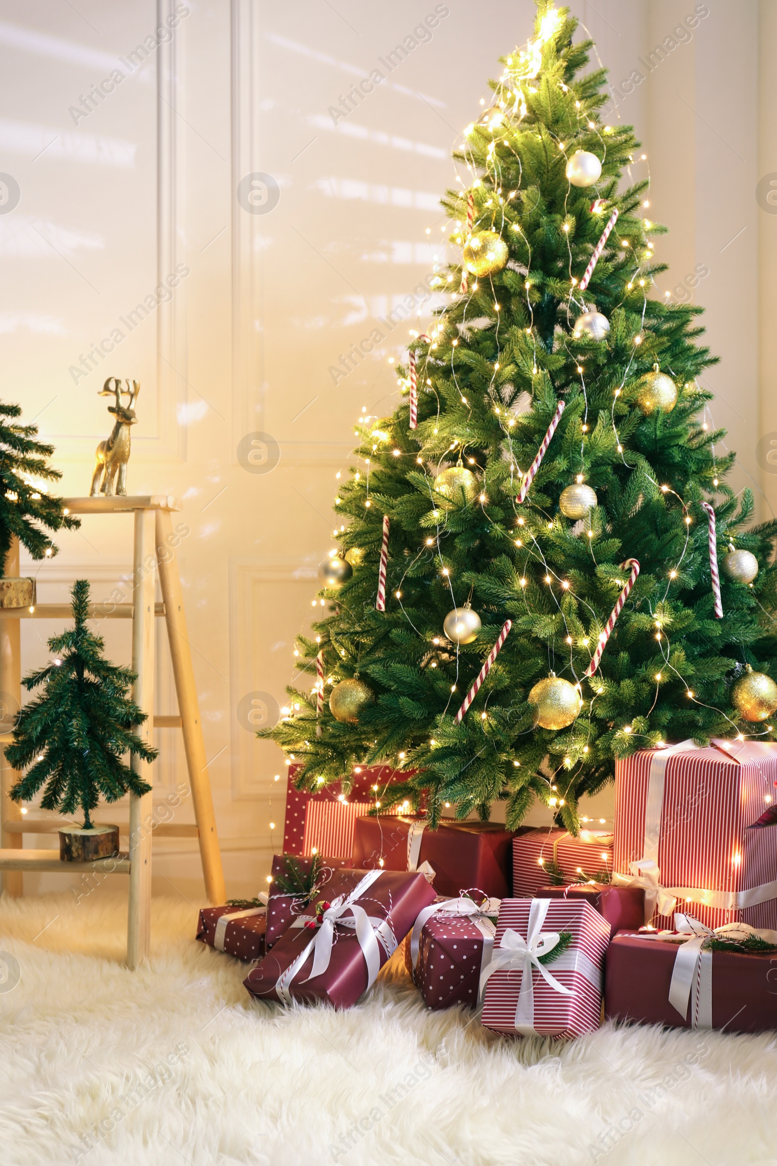 Photo of Many different gifts under Christmas tree indoors