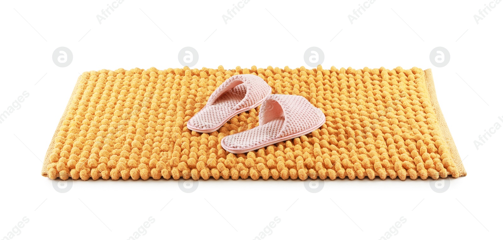 Photo of New yellow bath mat with soft slippers isolated on white