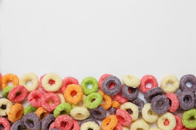 Photo of Sweet tasty colorful corn rings on white background, top view