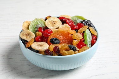 Photo of Bowl with different dried fruits on wooden background. Healthy lifestyle