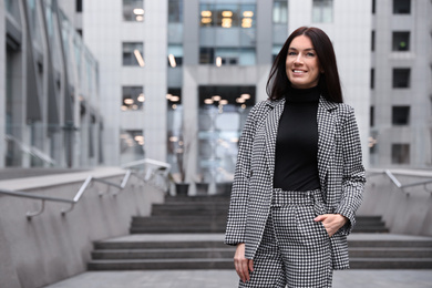 Photo of Portrait of beautiful woman in stylish suit on city street. Space for text