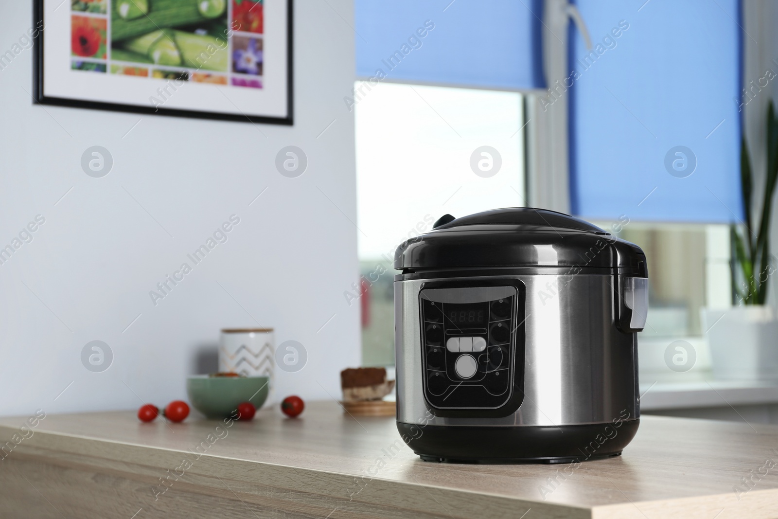 Photo of Modern multi cooker and ingredients on table indoors, space for text