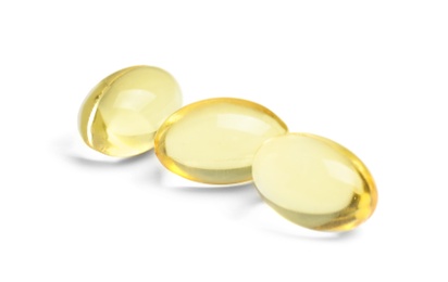 Photo of Cod liver oil pills on white background