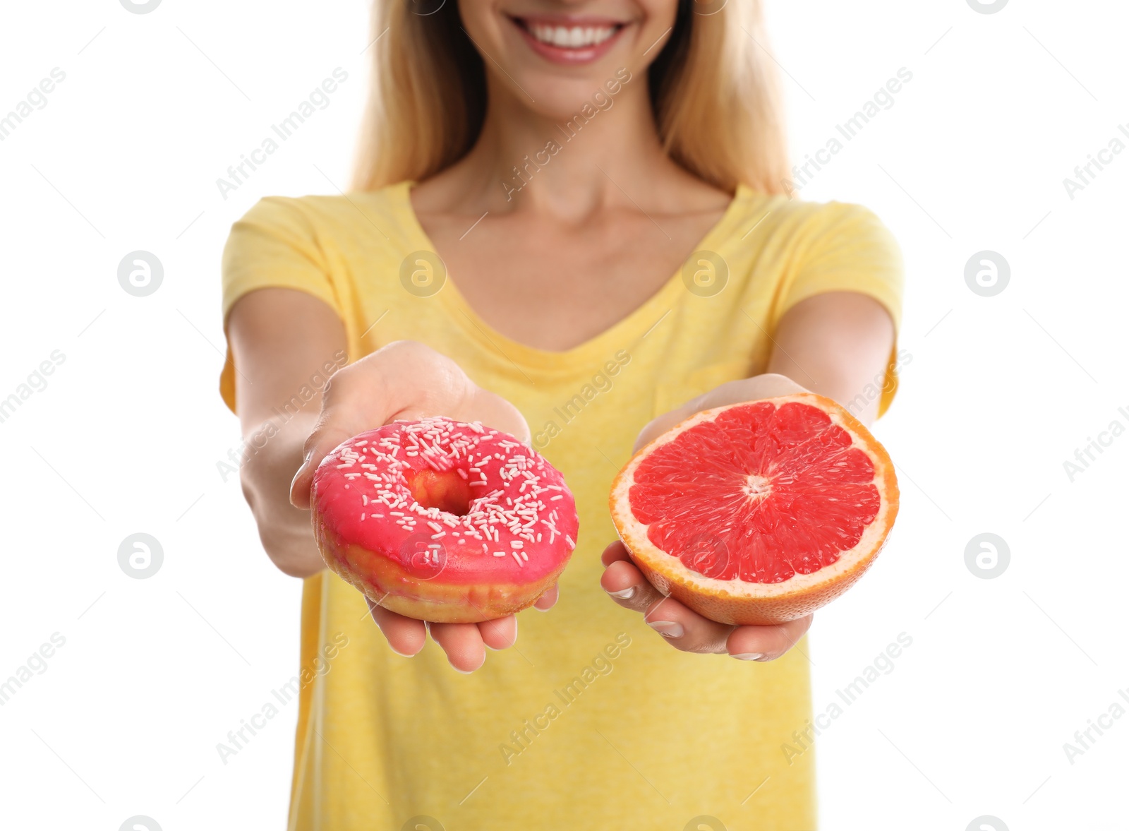 Photo of Woman choosing between doughnut and fresh grapefruit on white background, closeup