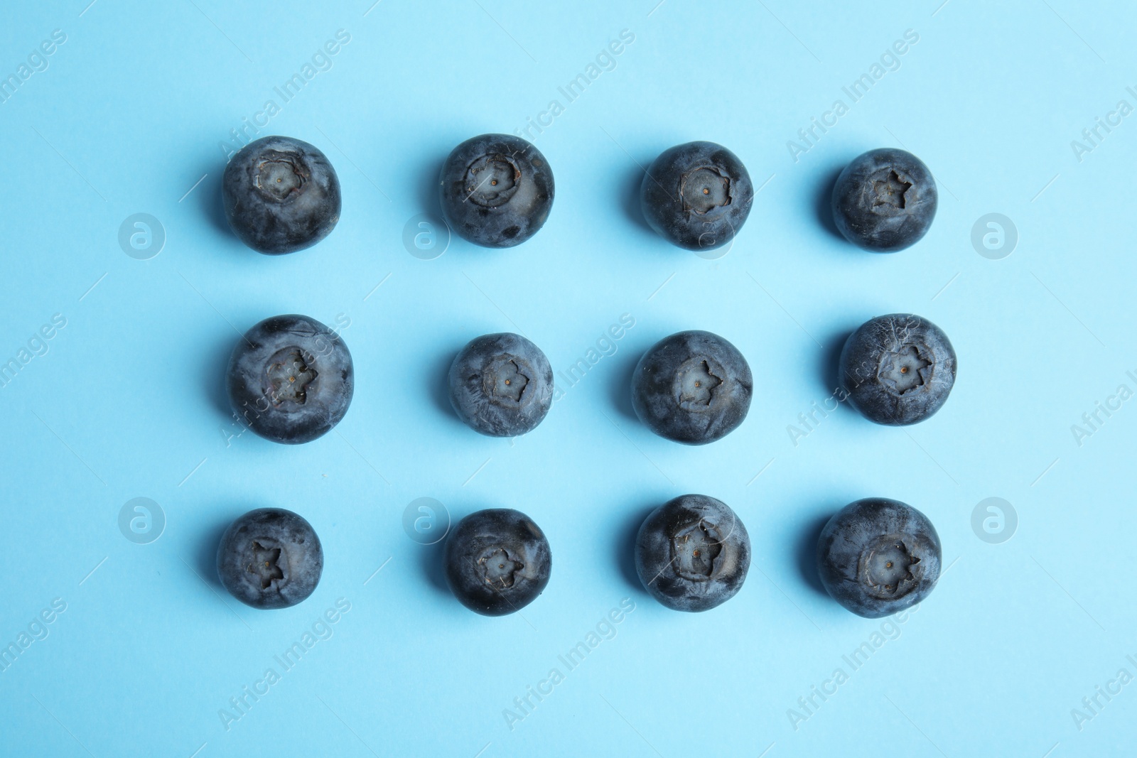 Photo of Tasty ripe blueberries on blue background, flat lay