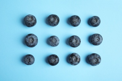 Tasty ripe blueberries on blue background, flat lay