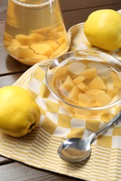 Photo of Delicious quince drink, fresh fruits and spoon on wooden table