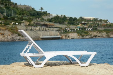Photo of One lounge chair on beach near sea