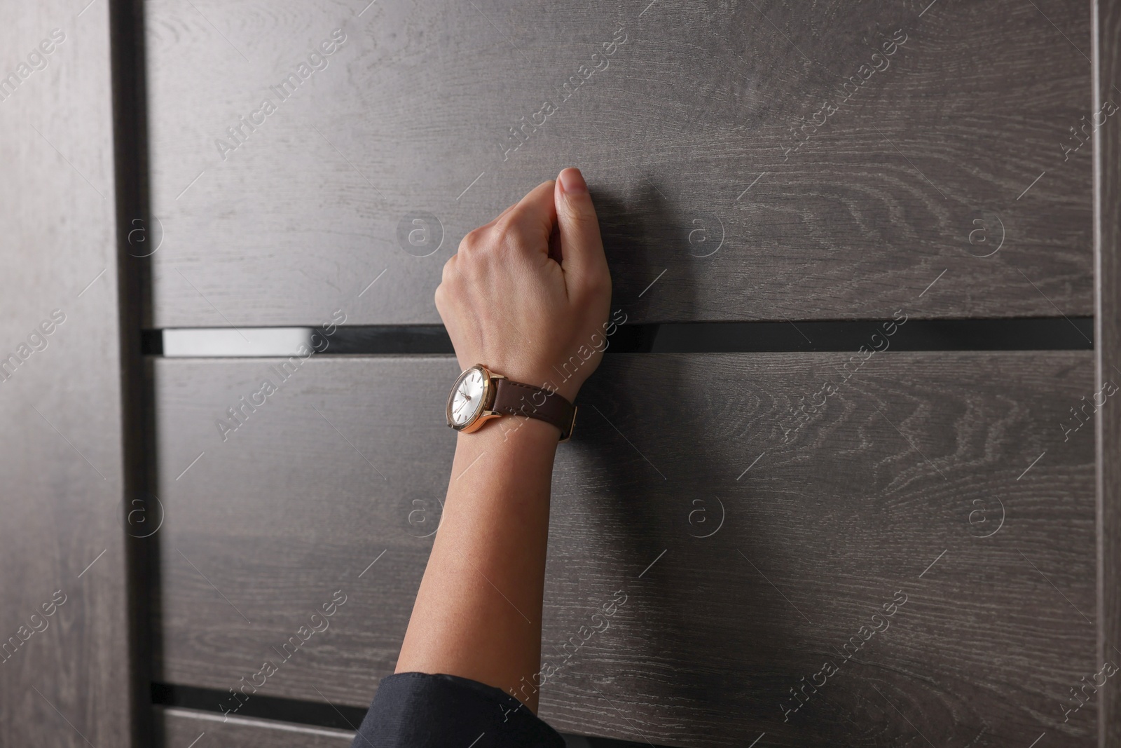 Photo of Collector knocking on door indoors, closeup view