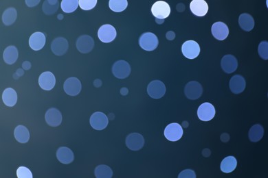 Photo of Blurred view of festive lights on blue background. Bokeh effect