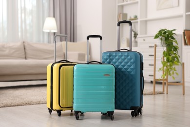 Three color suitcases on floor at home
