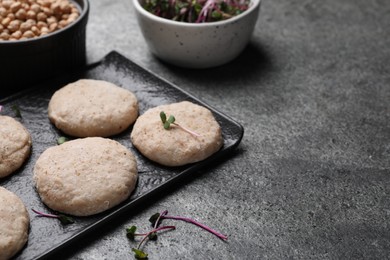 Photo of Raw vegan nuggets and spices on grey table, space for text