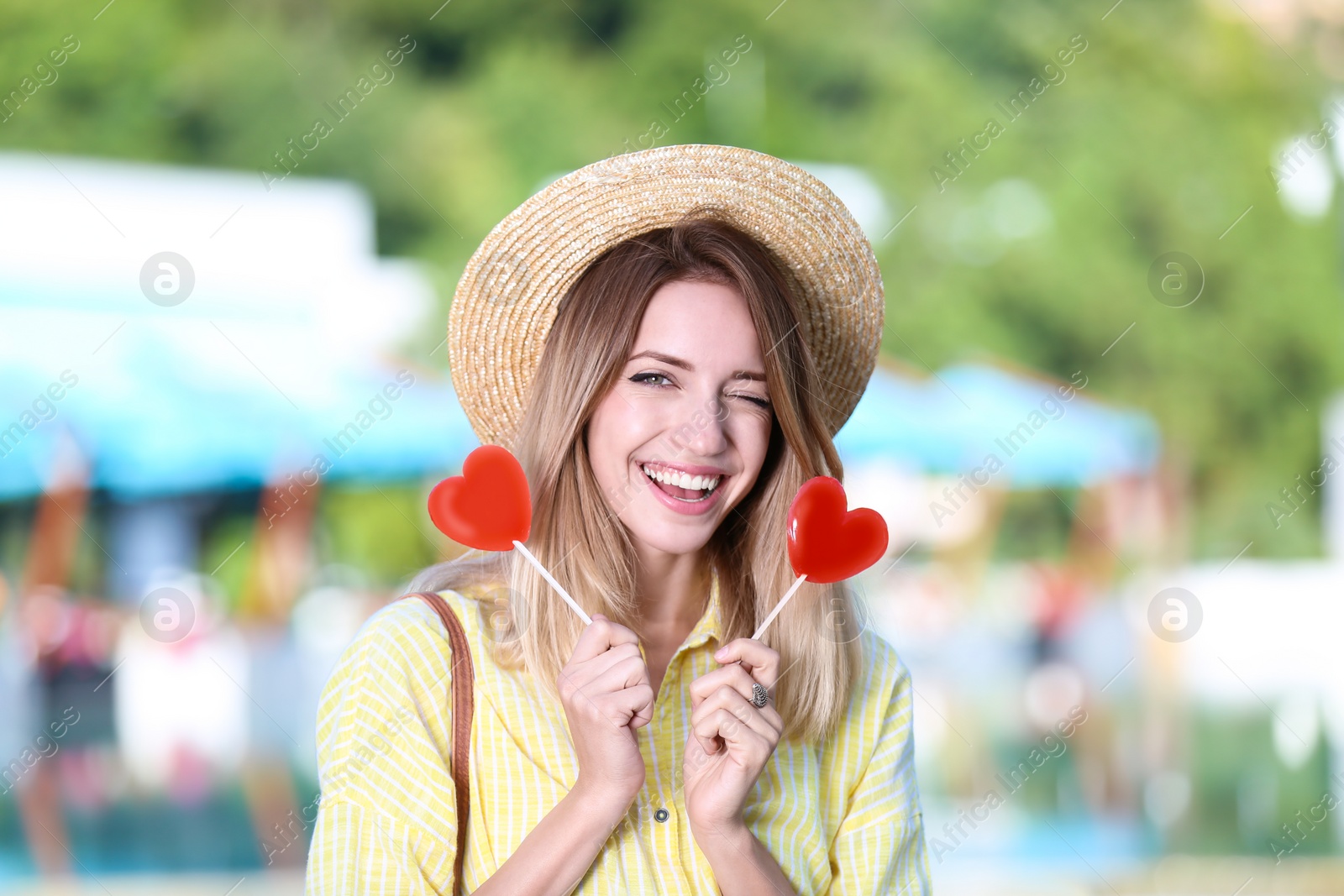 Photo of Beautiful smiling woman with candies on city street