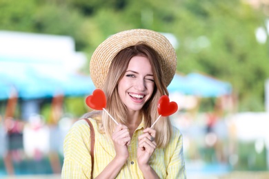 Beautiful smiling woman with candies on city street