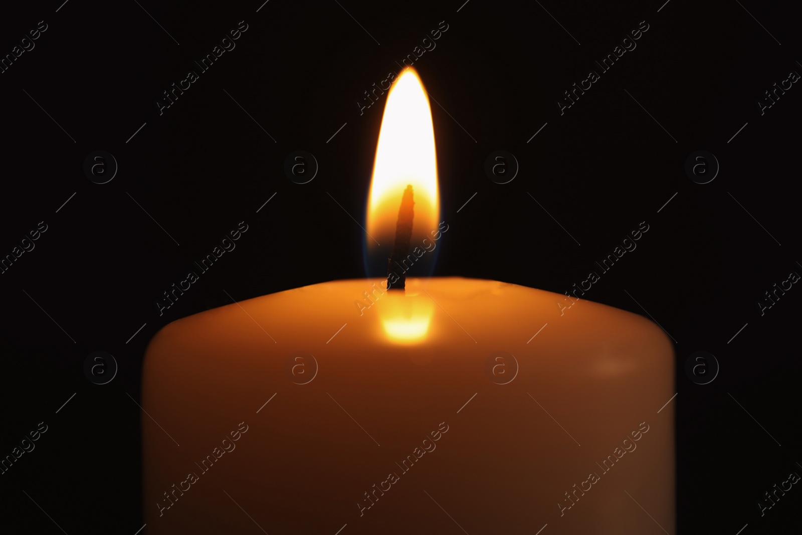 Photo of Burning candle in darkness, closeup. Memory day