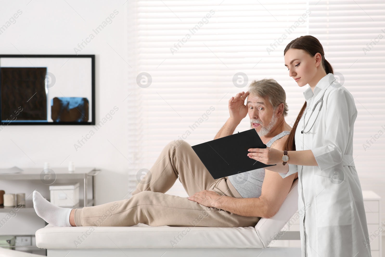 Photo of Professional female orthopedist consulting patient in clinic