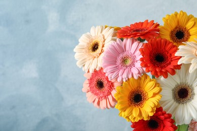 Photo of Bouquet of beautiful colorful gerbera flowers on light blue background. Space for text