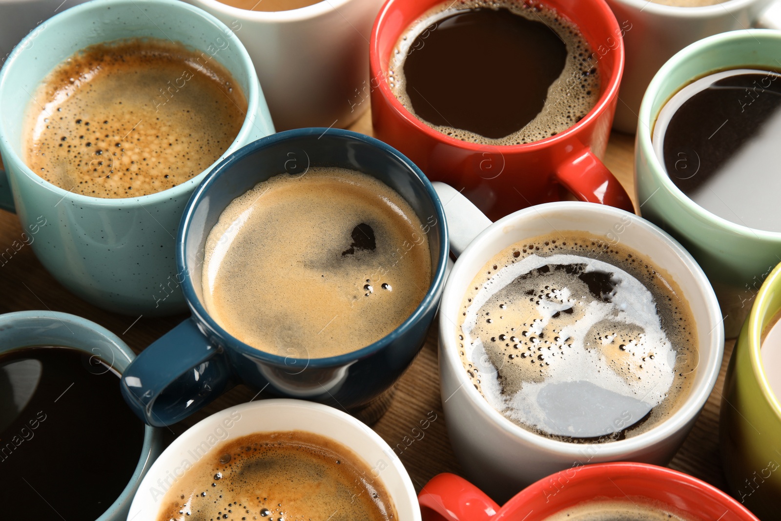 Photo of Cups of fresh aromatic coffee on wooden table. Food photography