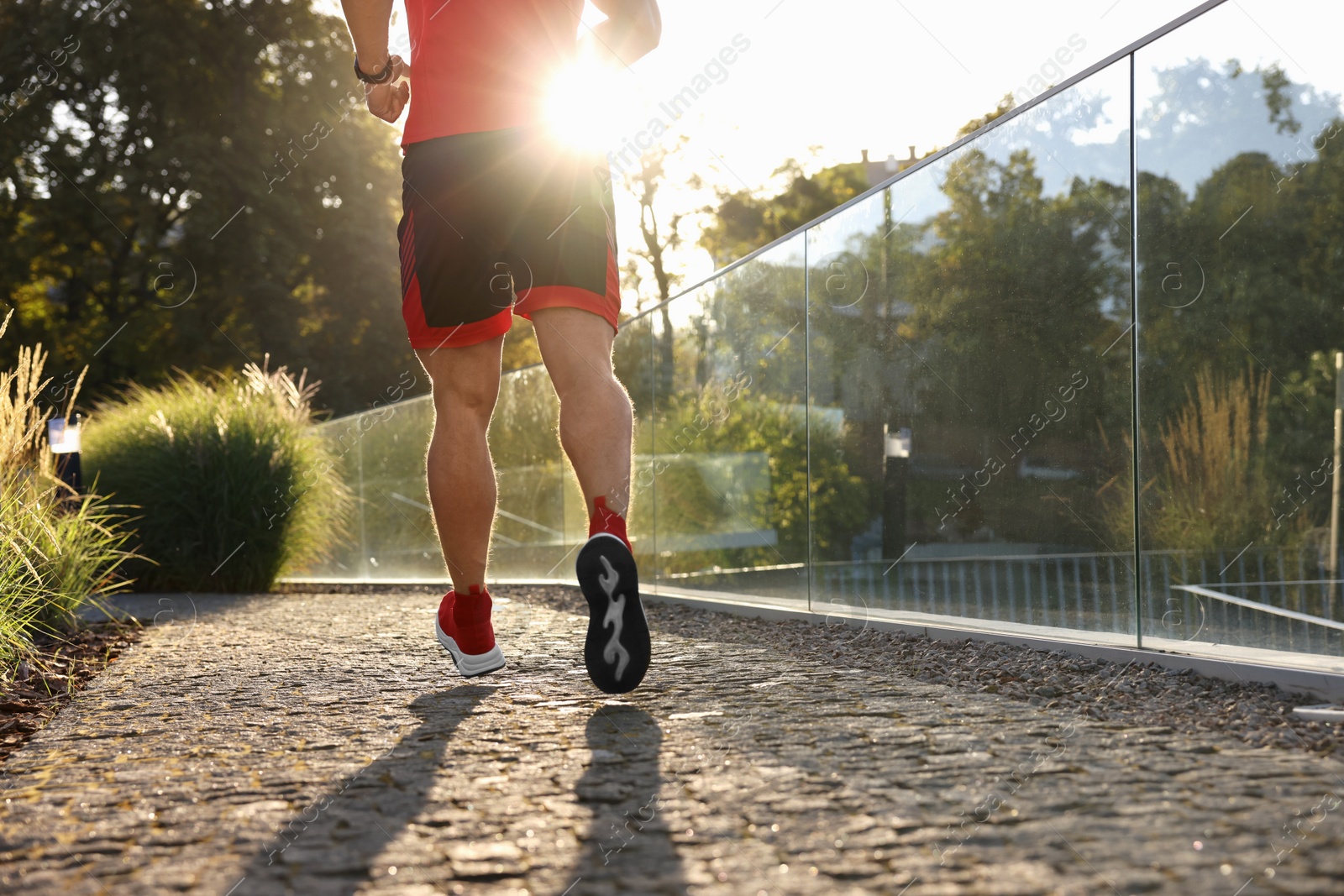 Photo of Man running outdoors on sunny day, closeup. Space for text