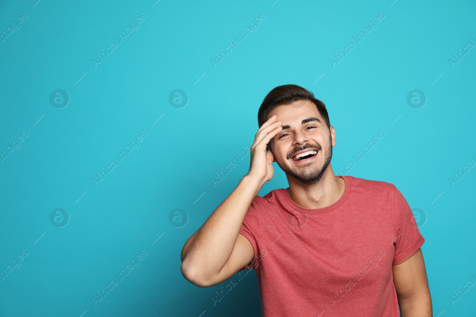 Photo of Handsome young man laughing against color background. Space for text