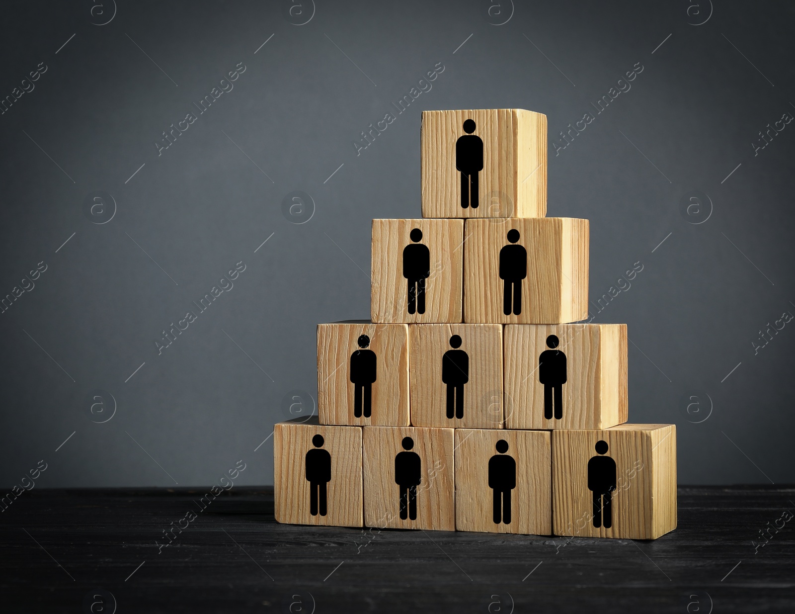 Image of Team and management concept. Pyramid of wooden cubes with human icons on table against grey background, space for text