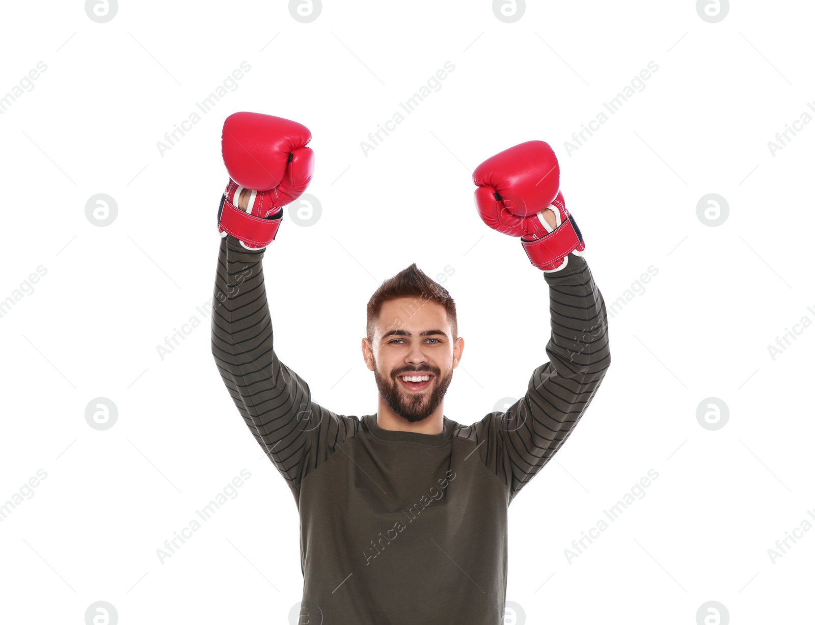 Photo of Happy young man with boxing gloves celebrating victory on white background