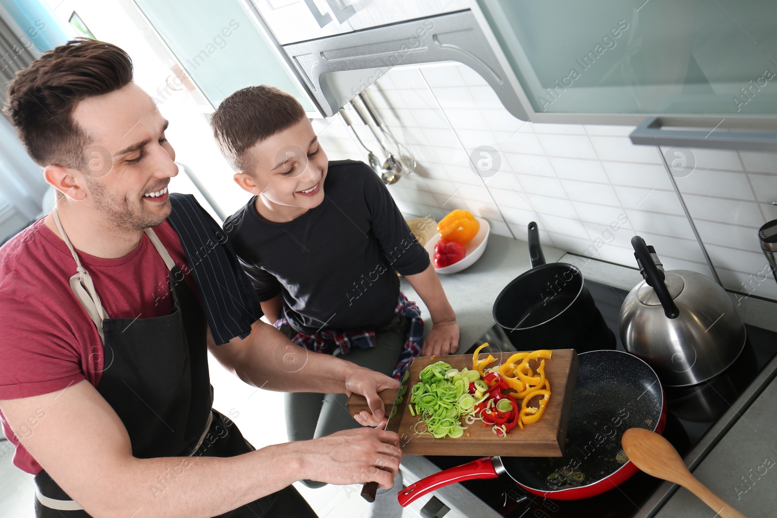 Photo of Dad and son cooking together in kitchen